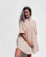 Camisola de corte oversize con estampado de rayas verticales en tonos beige y blanco. Presenta cuello mao, cierre frontal con botones y dos bolsillos delanteros en contraste de material tipo gamuza.