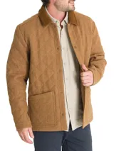 Chaqueta marrón acolchada con patrón de rombos, cuello de pana marrón, cierre con broches metálicos, bolsillos frontales y bolsillo interno. Confeccionada en lana con relleno Thermore de fibras recicladas.