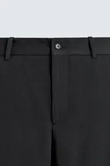 Pantalón de corte relaxed fit confeccionado en tejido con mezcla de lana, con bolsillos delanteros y traseros de vivo, cierre frontal con cremallera y botón.