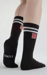 Medias 3/4 de algodón color negro, con diseño deportivo que incluye dos franjas blancas horizontales en la parte superior, el número 90 bordado en rojo y blanco, y el logo de la marca Luxo en la zona del talón.