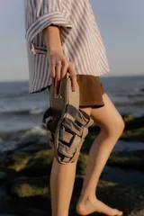 Sandalias bajas color beige con tiras de cuero entretejidas.