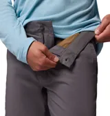 Pantalón chino Columbia modelo Roc Chino Pant, color gris, de corte recto con trabillas para cinturón, bolsillos inclinados y bolsillo lateral con cierre de cremallera.