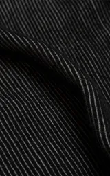 Sweater de cuello redondo con diseño de tejido acanalado vertical en color negro. Presenta detalles de costuras en contraste blanco en los hombros y en el ruedo, con un corte holgado y terminaciones en punto rib.