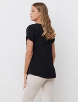 Blusa negra de crepe, con cuello a la base y manga corta.