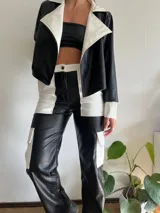 Pantalón cargo de cuero sintético con diseño bicolor en blanco y negro y textura tipo piel de cocodrilo. Presenta bolsillos laterales tipo cargo y corte recto.