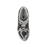 Championes New Balance modelo 1906R, de diseño técnico y deportivo en tonos gris, blanco y plateado, con detalles en verde lima. Presenta una estructura de malla transpirable con refuerzos sintéticos y entresuela amortiguada.