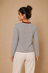 Remera de manga larga con diseño de rayas horizontales en tonos marrón, blanco y azul. Presenta cuello redondo al tono y un corte recto y cómodo.