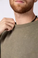 Remeron de algodón rústico con efecto de lavado gastado, corte oversize, cuello redondo y mangas cortas con terminaciones al corte.