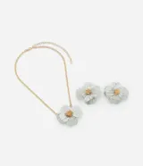 Conjunto de bisutería compuesto por un collar corto de cadena dorada con dije de flor y un par de aros tipo botón con diseño de flor a juego. Las piezas presentan un acabado bicolor con pétalos plateados y centro dorado.