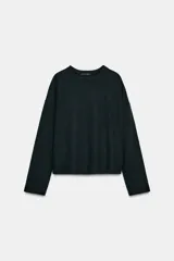 Top de tejido soft con cuello redondo, manga larga y bajo recto.