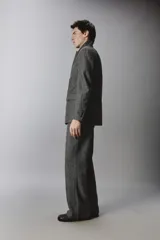 Pantalón de traje relaxed fit en color gris oscuro con diseño de espiga. Cuenta con bolsillos frontales, bolsillos traseros de vivo y cierre frontal con cremallera y botón.