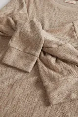 Buzo de punto con textura de rombos y líneas verticales, cuello redondo y mangas largas con caída relajada.