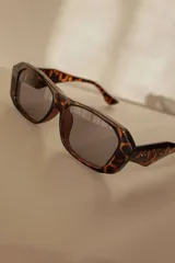 Lentes de sol con marco geométrico color carey y lentes grises con protección UV400.