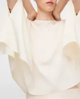 Top satinado blanco estilo capa de línea rectangular, con escote redondo, pliegue en la espalda y cierre de botón con lágrima.