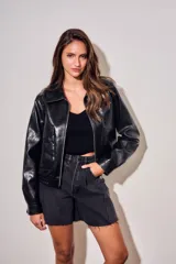 Campera bomber de cuero sintético negro, de corte oversize, con cuello solapa, cierre frontal metálico y bolsillos frontales con solapa.
