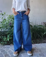 Pantalón de jean estilo wide leg, color azul oscuro, con diseño de pierna ancha y ruedo desflecado.