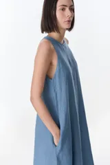 Vestido largo blanco de lino, sin mangas y con bolsillos laterales.