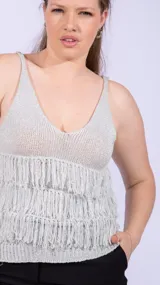 Top de tejido de punto plateado brillante, con escote en V y tirantes finos. La parte inferior está decorada con múltiples capas de flecos largos.