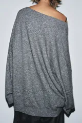 Jersey oversize color beige melange, confeccionado con lana, con cuello en V y manga larga.