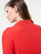 Vestido camisero largo color rojo, confeccionado en lino y viscosa, con cartera de botones delanteros centrales y bolsillo delantero superior con terminación de galón metalizado.