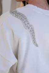 Sweater negro de algodón con cuello redondo y detalle de lentejuelas brillantes en el hombro.