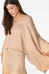 Blusa de algodón azul marino con escote en V, mangas murciélago amplias y diseño corto de corte asimétrico.