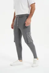 Babucha de estilo cargo en color gris, con cintura elástica ajustable mediante cordón, bolsillos laterales con solapa y puños elásticos en los tobillos.