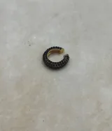 Set de tres aros trepadores con brillos, uno en tono bronce con piedras negras, uno dorado con piedras transparentes y uno plateado con piedras transparentes.