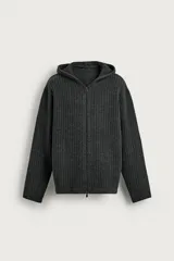 Chaqueta de punto con textura acanalada, corte relajado, cierre frontal de cremallera, capucha y mangas largas con terminaciones en rib.