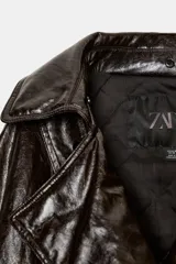 Chaqueta de efecto cuero con acabado brillante, cuello de solapa con aplicación de pelo sintético extraíble, cierre frontal cruzado con botones, mangas largas con puños ajustables y bajo elástico. Cuenta con forro interior acolchado.