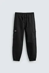 Pantalón cargo de corte slim fit en color negro, confeccionado en tejido de algodón con elasticidad. Presenta cintura elástica ajustable con cordón, bolsillos laterales tipo cargo con solapa y bajo acabado en puño elástico.