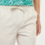 Pantalón de corte recto en color gris claro, confeccionado en tela de algodón, con cintura elástica y bolsillos laterales.