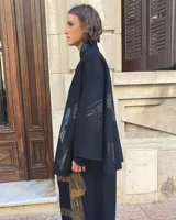 Capa negra de paño de lana con cuello mao y cierre frontal con ganchos ocultos. Estampado serigráfico negro brillante en cuerpo y cuello.