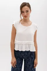 Remera blanca de lyocell y algodón, con mangas cortas con volados y frunce en la cintura.