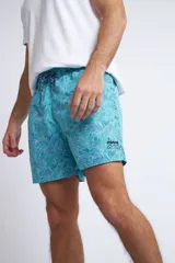 Short de baño con cintura elástica y cordón ajustable, confeccionado en tela ligera de secado rápido. Presenta un estampado botánico integral en tonos amarillos, blancos y azules, con dos bolsillos delanteros y uno posterior.
