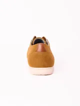 Zapato acordonado de estilo casual confeccionado en material sintético tipo gamuza color azul marino, con suela plana de goma en tono claro y detalles de cuero en el talón y la lengüeta.
