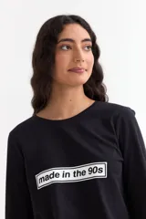 Remera de manga larga color beige con cuello redondo a la base. Presenta un estampado frontal con un dibujo de labios en color fucsia y la palabra 'BESITO' en color negro.