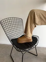 Sueco de estilo casual confeccionado en símil gamuza color marrón, con interior y borde superior revestido en corderito sintético color crema. Presenta una suela de plataforma plana de goma en tono marrón oscuro.