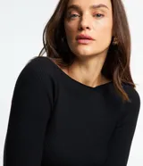 Blusa de punto de manga larga con cuello bote y textura acanalada vertical. Presenta un diseño ajustado al cuerpo, confeccionada en una mezcla de viscosa y poliamida.