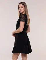 Vestido corto azul de seda fría elastizada, con mangas cortas de encaje calado, lazo para ajustar en la cintura y ruedo con volado plisado.
