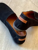 Alpargatas de gamuza color azul marino, con diseño clásico de calce fácil, suela baja y pequeña etiqueta lateral con la marca Sierra Mora.