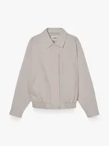 Campera bomber color beige con cuello solapa, confeccionada en 100% algodón, con cierre frontal con cremallera y acabado elástico en el bajo.
