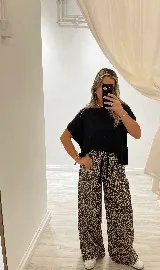 Remerón negro de morley de algodón, con manga corta, dos pequeñas aberturas frontales y terminación en pico en la parte trasera.