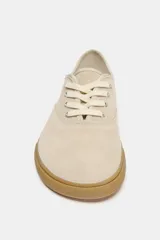 Zapatillas tipo deportiva confeccionadas en serraje color beige, con diseño barefoot de puntera amplia, suela flexible efecto engomado y cierre mediante cordones al tono.