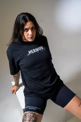 Calza biker negra de tiro alto con el logo de la marca en color blanco en la pierna izquierda.