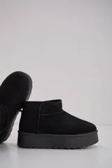 Bota corta estilo australiano en color negro, con plataforma plana y forro interior suave.