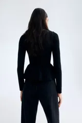 Top de punto acanalado entallado, con escote bote, mangas largas y detalle de peplum con vuelo en la cintura.