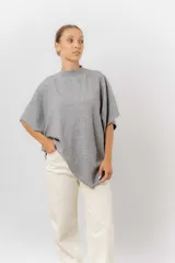 Sweater de tejido de punto color negro, con cuello semi alto y mangas cortas amplias. Presenta una silueta relajada y caída fluida.