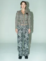 Pantalón de corte recto y tiro medio-alto, confeccionado en algodón grueso con apariencia de denim. Presenta un estampado abstracto en tonos grisáceos y negros, con bolsillos delanteros y traseros.