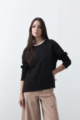 Remera de manga larga en color blanco, con calce relajado y diseño minimalista. Presenta un cuello redondo clásico y puños rectos, ideal para usar como prenda base en capas.